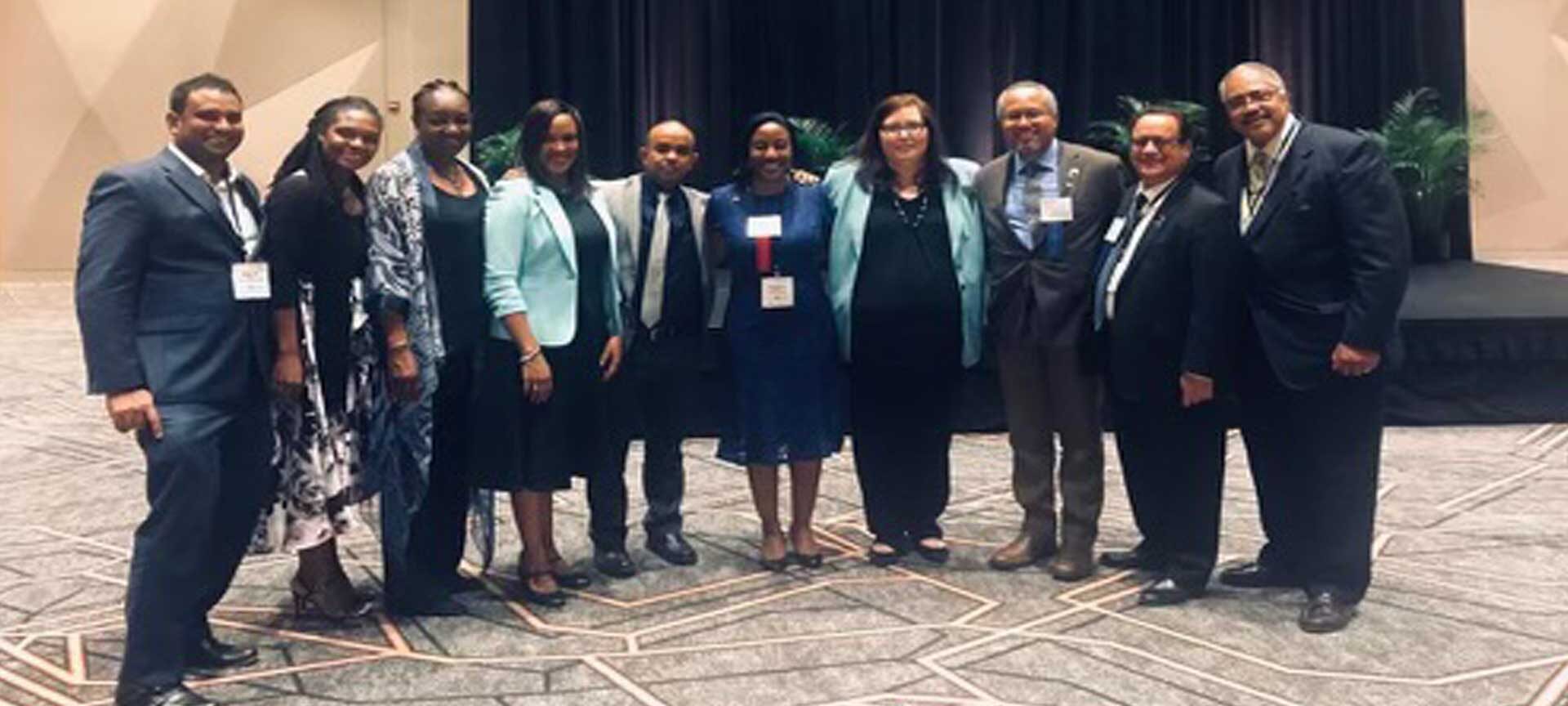 Formal team group photo of professionals standing in a conference setting